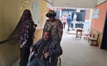 بالصور.. ضابط شرطة يساعد معاق للوصول إلى لجنة الإستفتاء على الدستور 