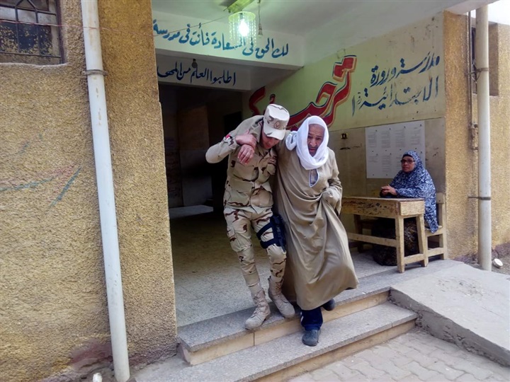 رئيس لجنة يخرج لإستقبال مسن مريض ومساعدته للإدلاء بصوته في الإستفتاء على الدستور ببنها