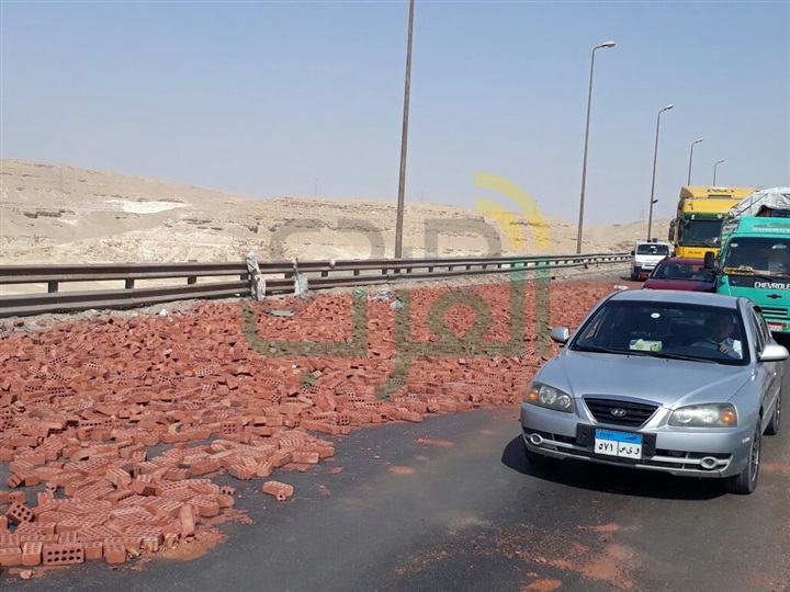 بالصور.. انقلاب سيارة نقل محملة بالطوب يسفر عن كثافات مرورية بالاوتوستراد 