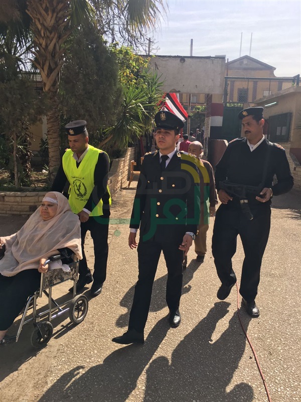 بالصور.. الشرطة تنقل مريضة من مسكنها للإدلاء بصوتها فى الانتخابات
